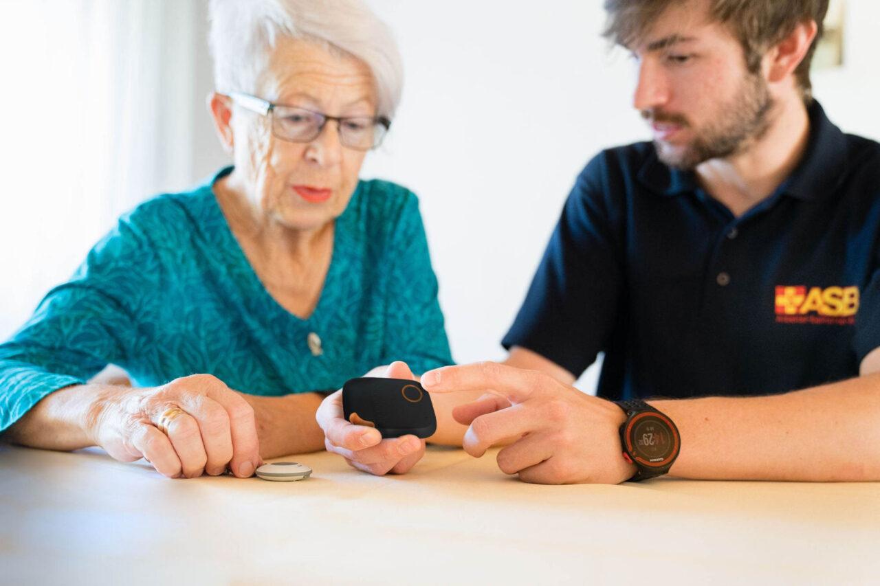 ASB Hausnotruf: Dame mit ASB-Mitarbeiter und Gerät